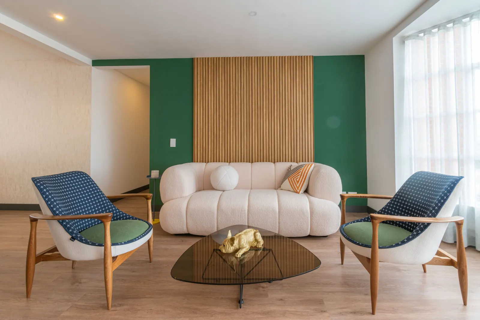 Sala minimalista con panel de madera y muro verde diseñada por Minim