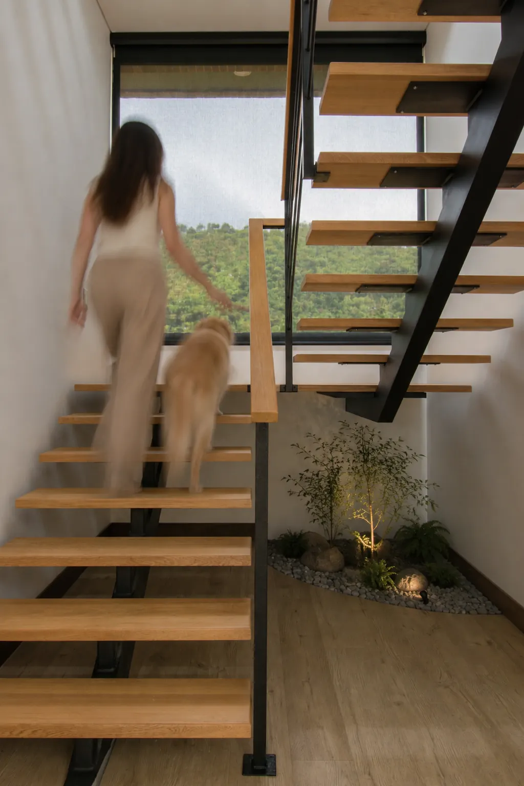 Escalera flotante junto a un jardín interior de inspiración feng shui