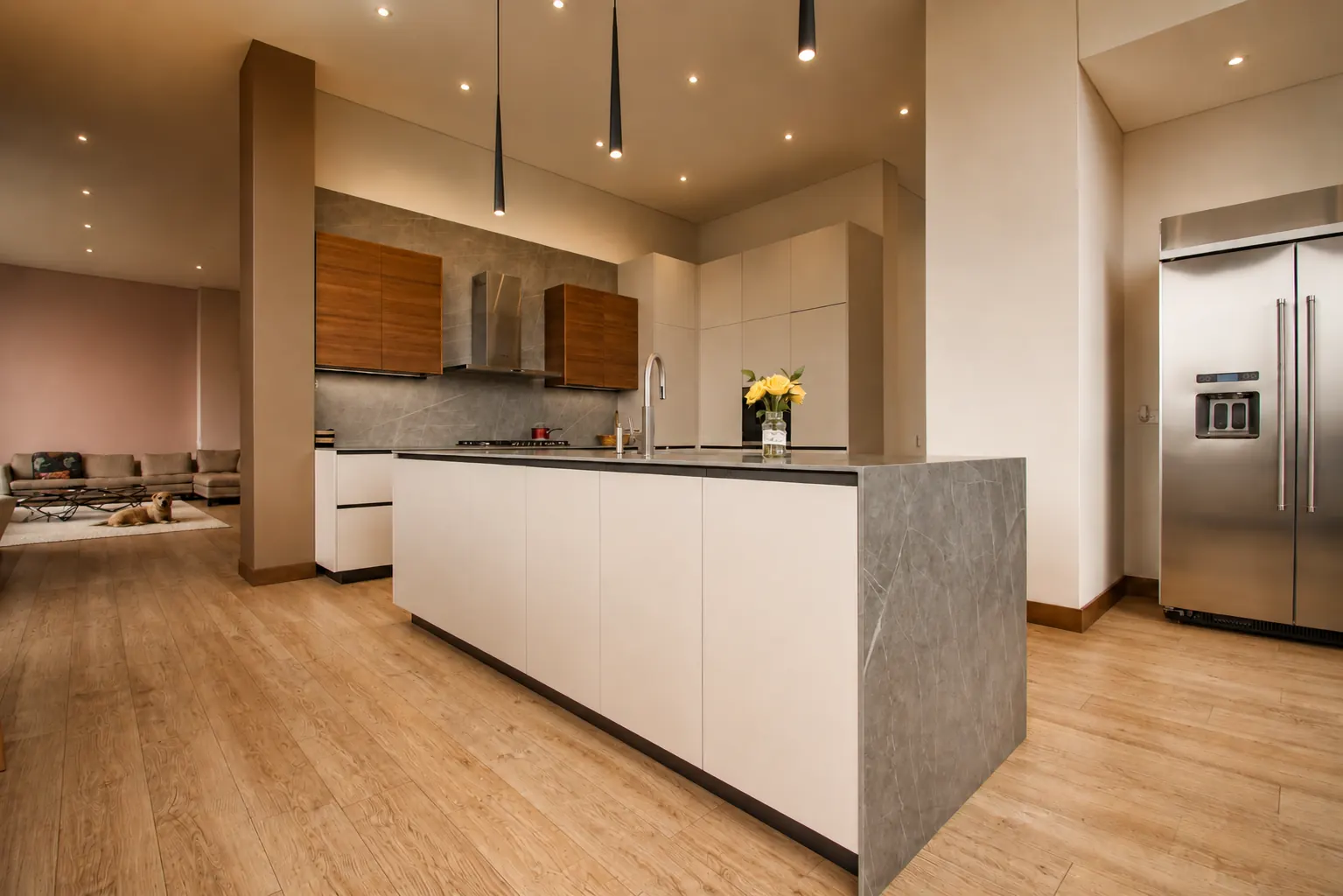 Cocina con isla en piedra y doble altura