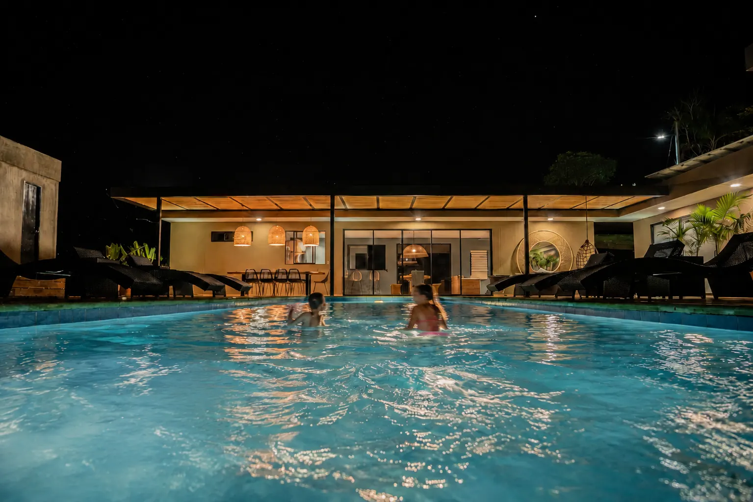 La casa se abre a la piscina al caer la noche